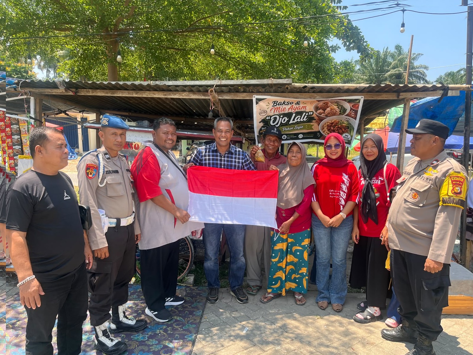 Jelang HUT ke-81 RI, Polsek Tapung Bagikan Bendera Merah Putih kepada Warga Desa Petapahan